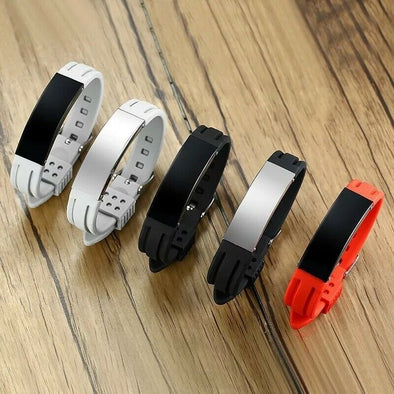Boston silicone and stainless steel medical ID alert bracelets showing the full colour range including grey, black and red on a wooden display table.