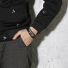 Havana customisable black leather and stainless steel medical alert bracelet with sliding magnetic clasp worn by a male model wearing black and grey.