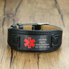Houston Wide black leather medical alert bracelet shown with an example of a personalised engraving and displayed on a wooden table.