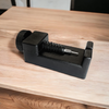 Black link removal tool with screw handle on wooden table