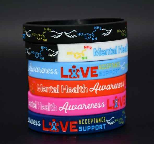Stack of mental health awareness wristbands in black, blue, red, pink and blue for awareness, acceptance and support.